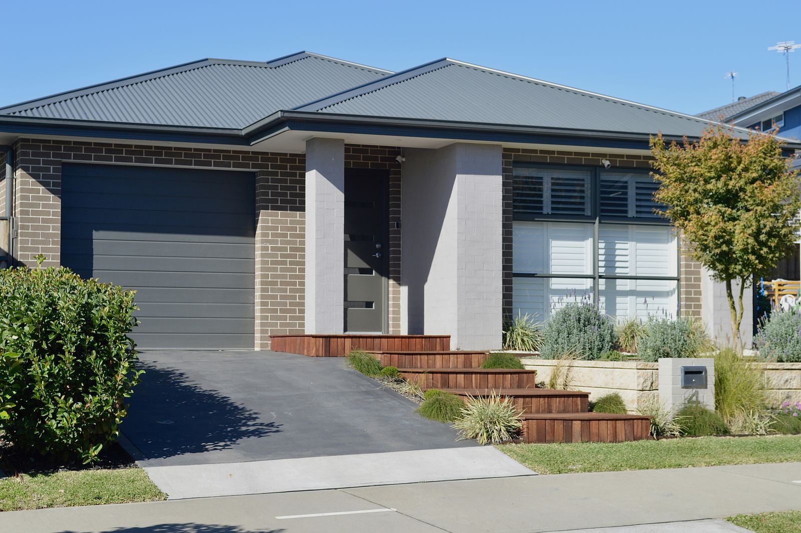 Residential entry with timber steps, retaining wall and planting